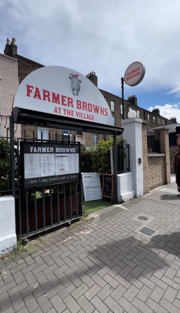Entrance sign and exterior of Farmer Browns at The Village in Dublin, a cozy neighborhood brunch spot with a menu displayed out front.